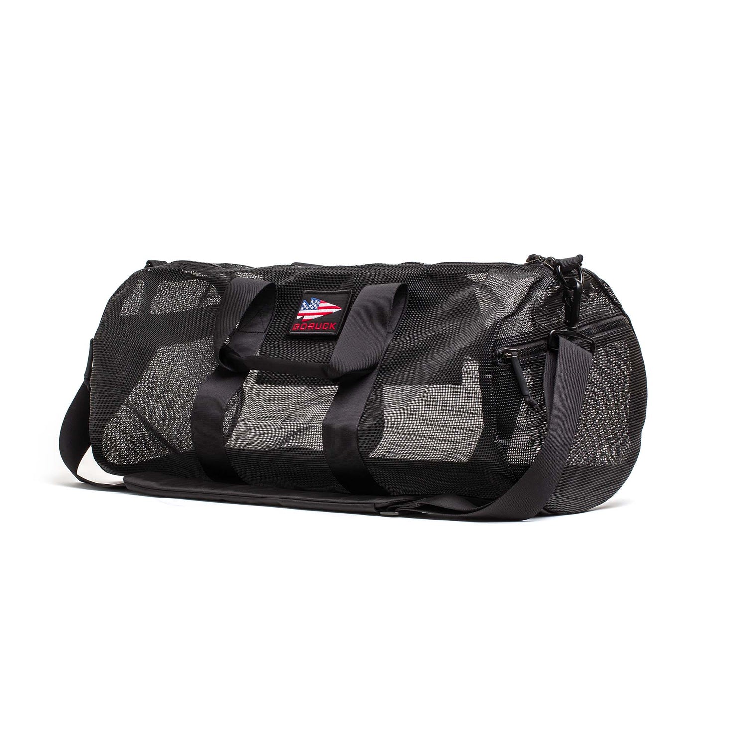The Mesh Gym Bag features a shoulder strap, mesh panels for ventilation, and a small American flag patch on the front.