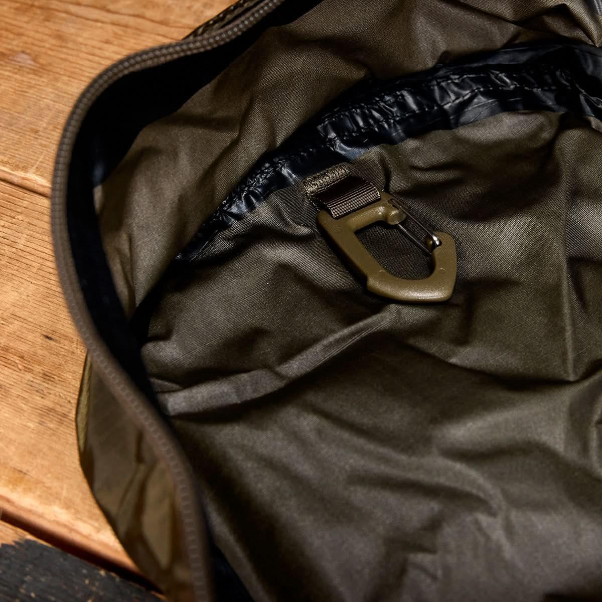 GORUCK Packable Bullet rucksack in ranger green with interior clip detail on wooden surface