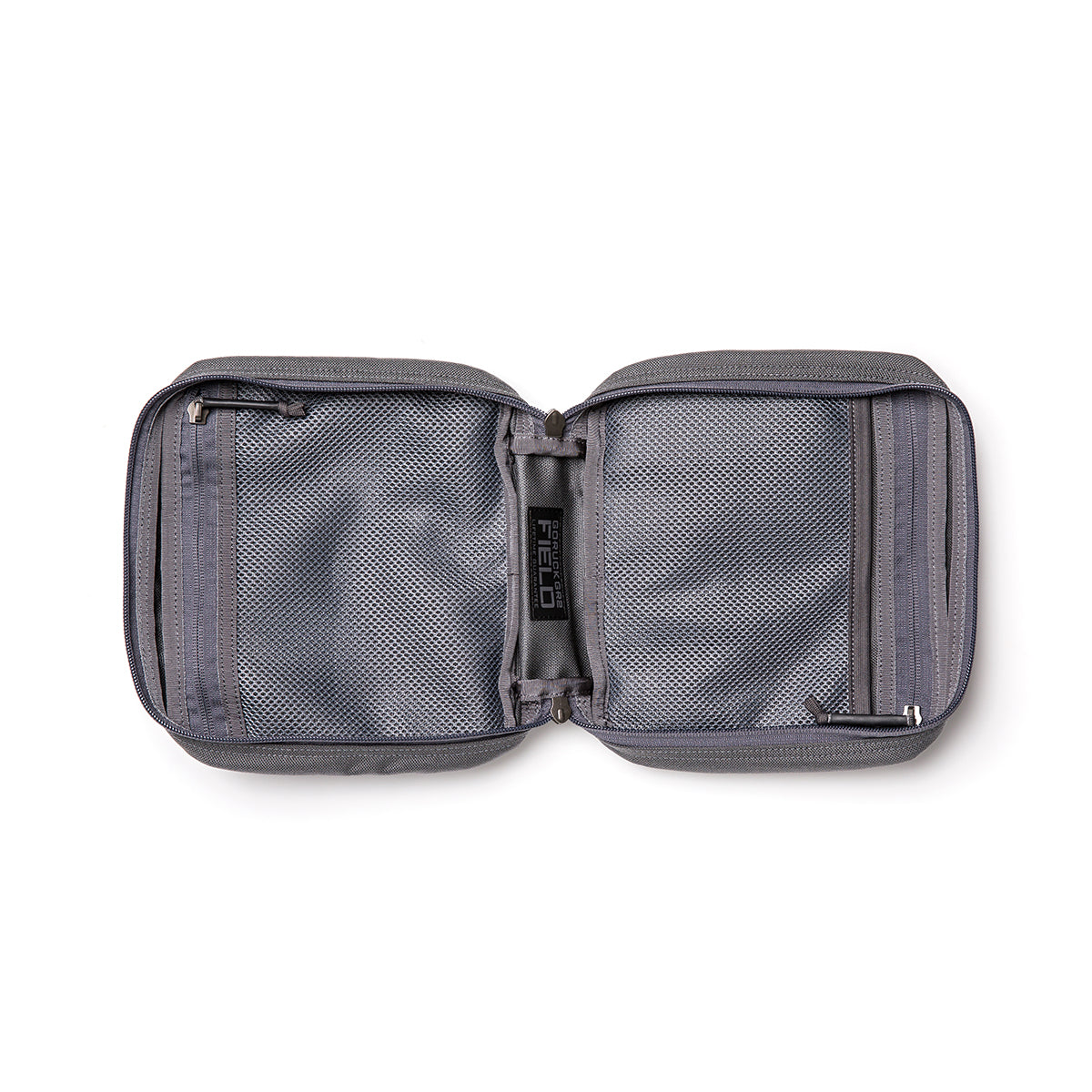 The GR2 Field Pocket is an open, gray travel pouch made from durable 1000D Cordura, featuring mesh compartments and zippers on each side.