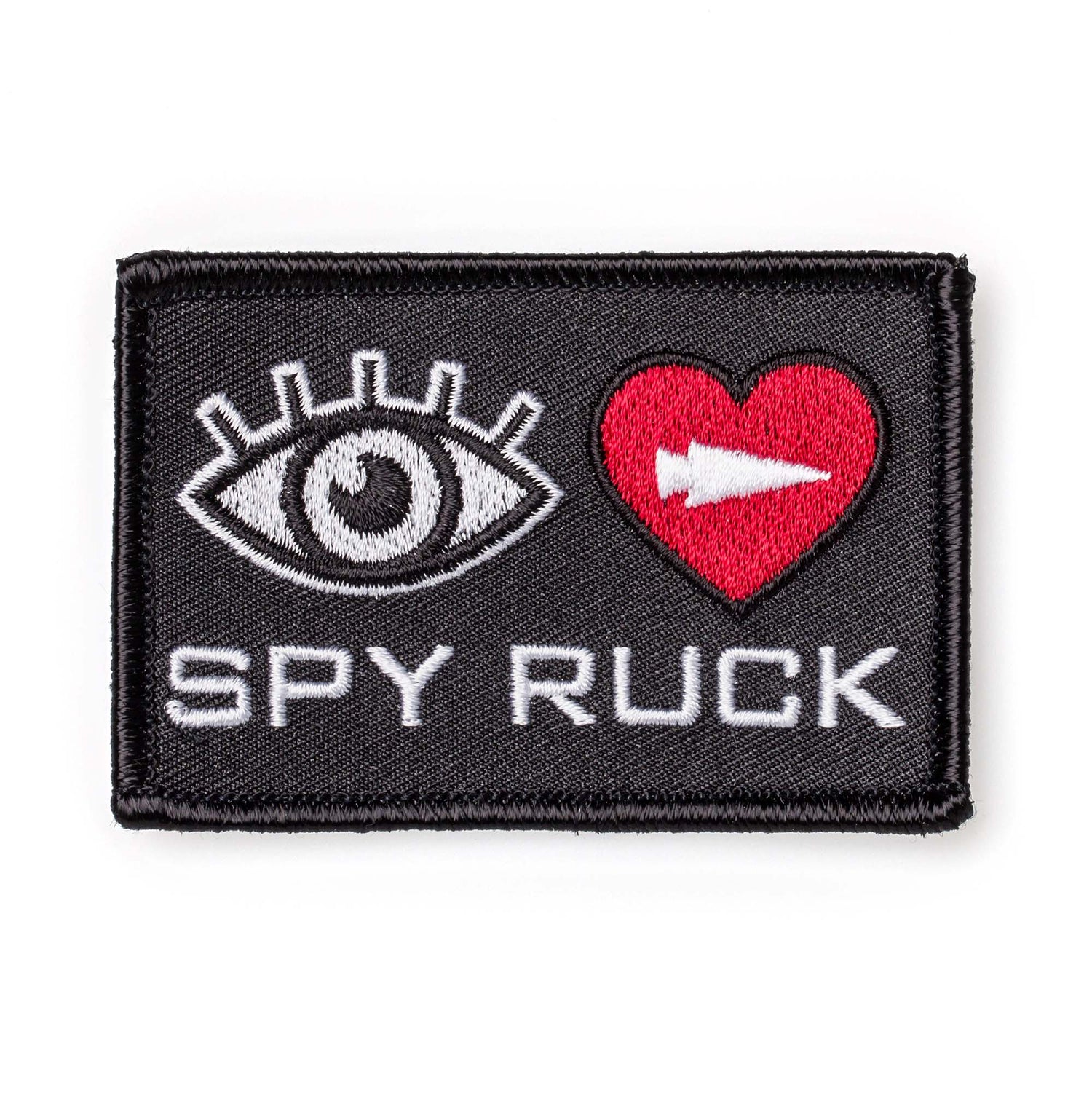 The Patch - Eye Heart Spy Ruck is a rectangular, eye-catching patch with an eye, red heart with white arrow, and