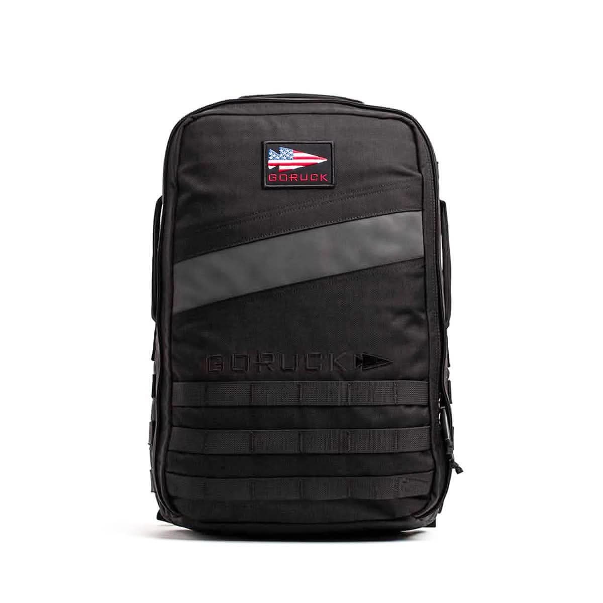 The Rucker 4.0 is a black rucksack with a GORUCK patch displaying the American flag and horizontal front straps, ideal for rucking or daily use.