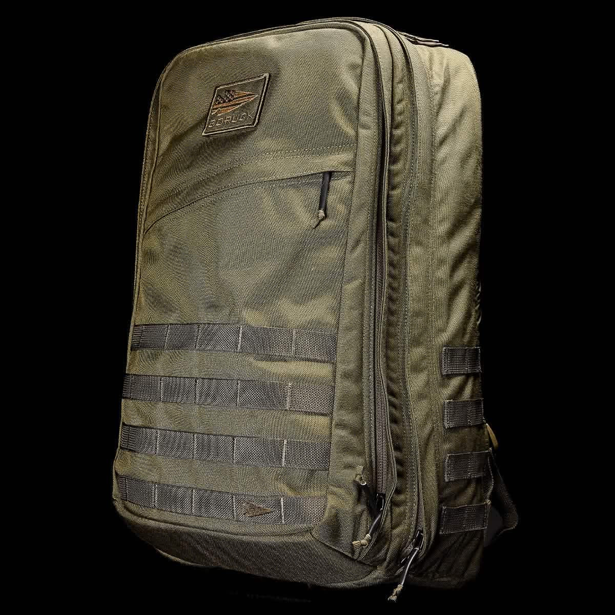 The GR2 - Cordura by GORUCK is a rugged olive-green tactical backpack featuring molle webbing on the front and sides, along with a brown patch at the top. This ruck includes multiple zipped compartments and a sturdy construction, making it ideal for outdoor adventures or Special Forces use.