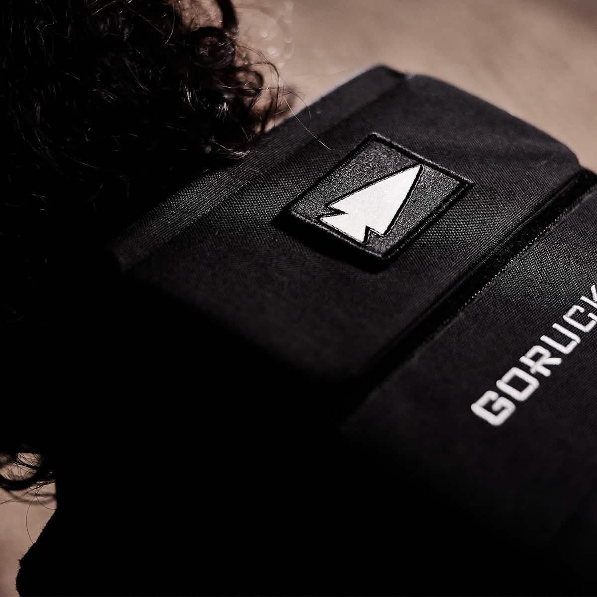 GORUCK black rucksack with reflective spearhead patch and visible GORUCK branding