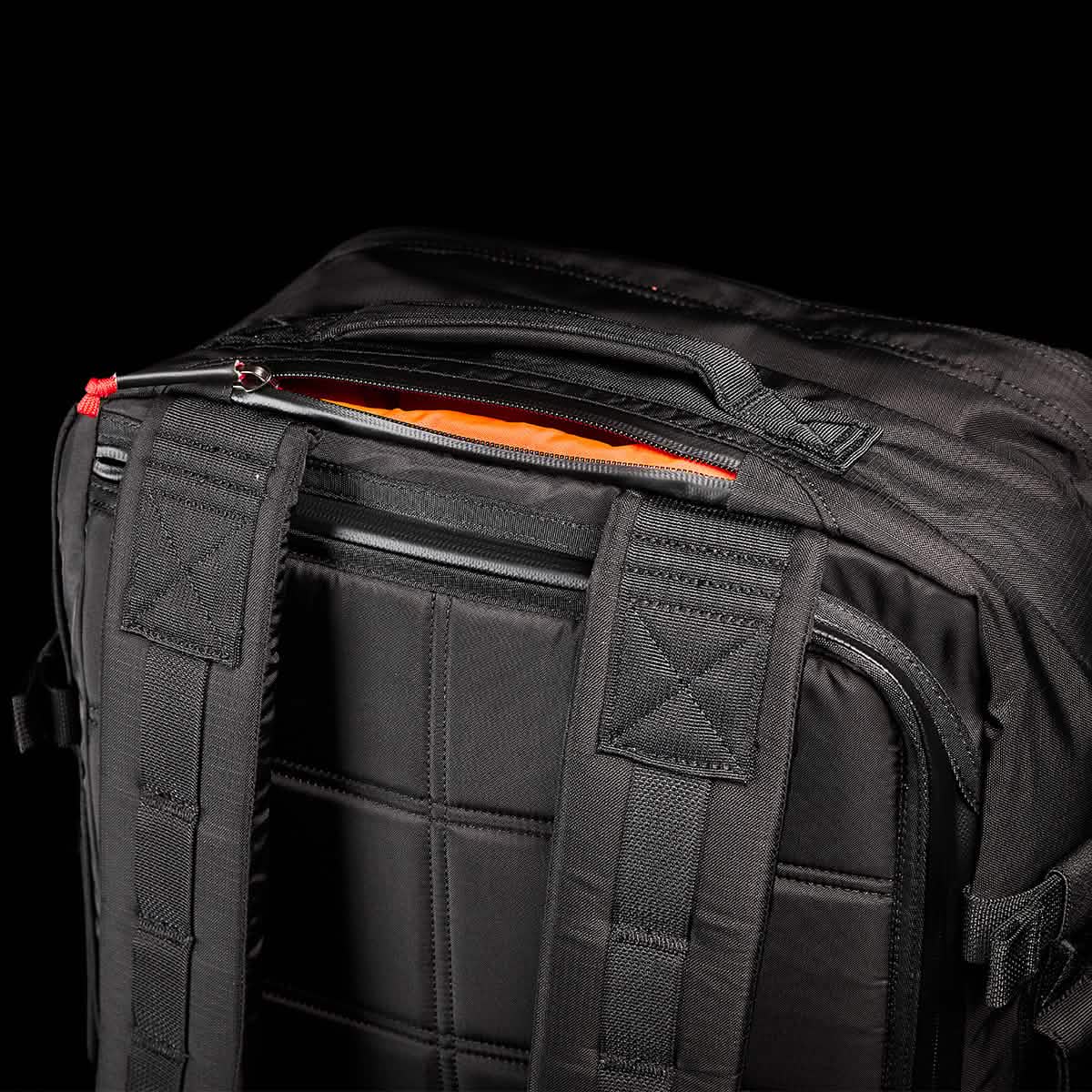 A black GORUCK GR3 - Ripstop ROBIC® backpack featuring quilted padding and adjustable straps is displayed against a black background. The top zipper is slightly open, showcasing an orange interior lining made from durable Robic nylon.