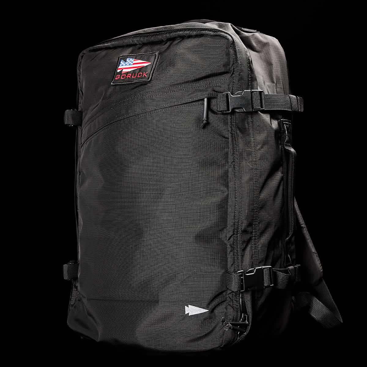 The product is a black, rectangular carry-on rucksack called the GR3 - Ripstop ROBIC® by GORUCK. It features side buckles, a top patch displaying the GR3® logo and text, and is crafted from durable Robic nylon with a textured fabric surface. The background color remains black.