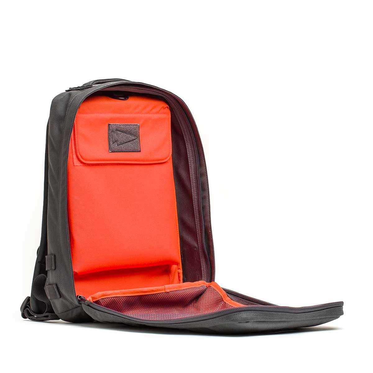 The Rucker 4.0 backpack in black features a bright orange interior, shown fully unzipped to reveal compartments ideal for organizing gear or carrying Ruck Plates during rucking.