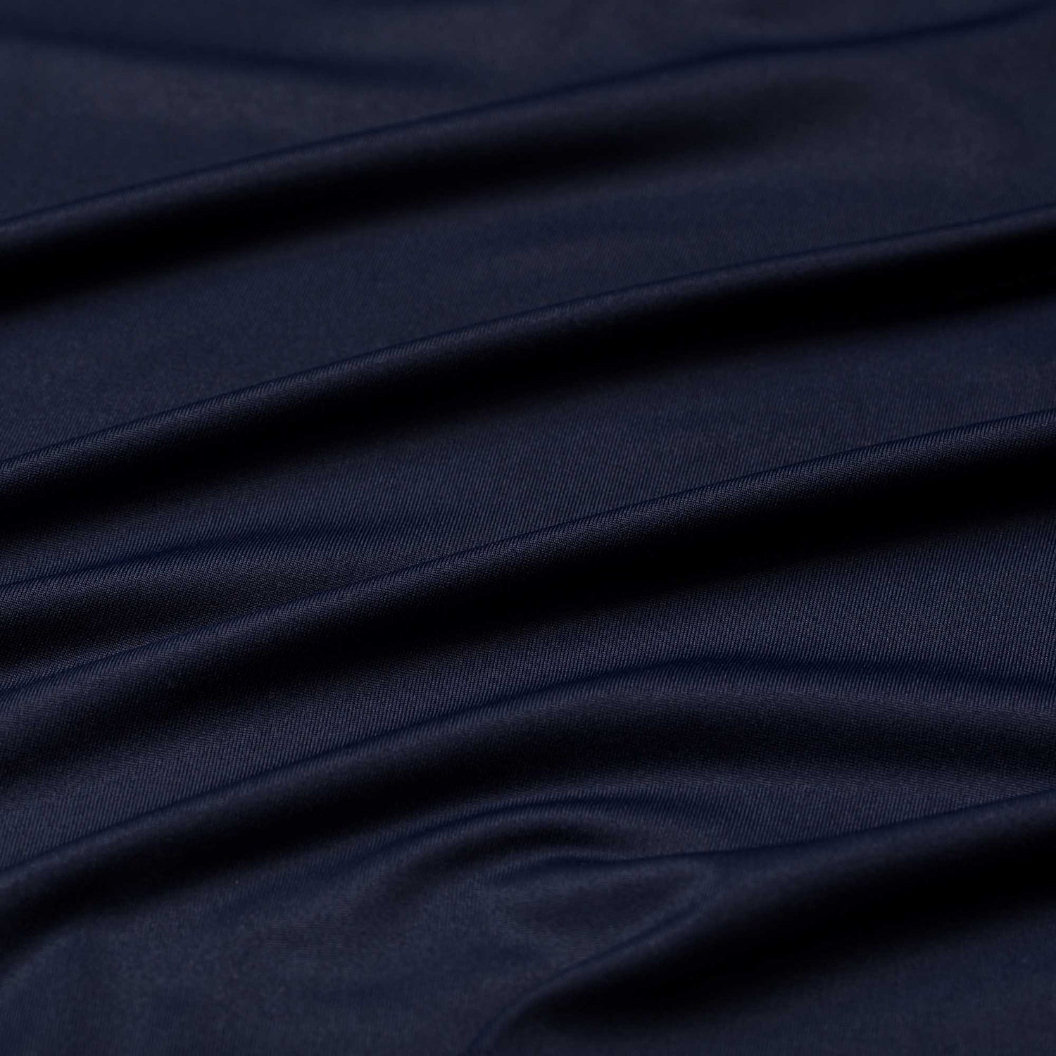 Close-up of smooth, dark navy EnduraKnit fabric on the Men's Long Sleeve Rucking Polo, showcasing soft horizontal folds and a subtle sheen.