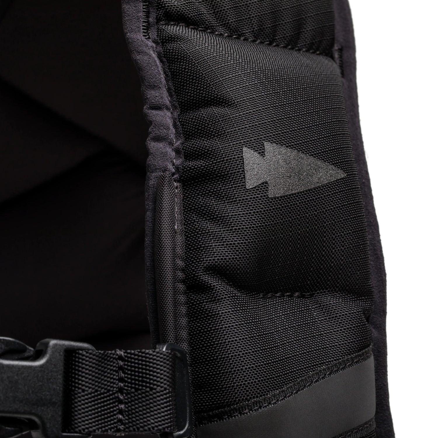 Close-up of black GORUCK rucksack strap with arrowhead logo and durable nylon stitching