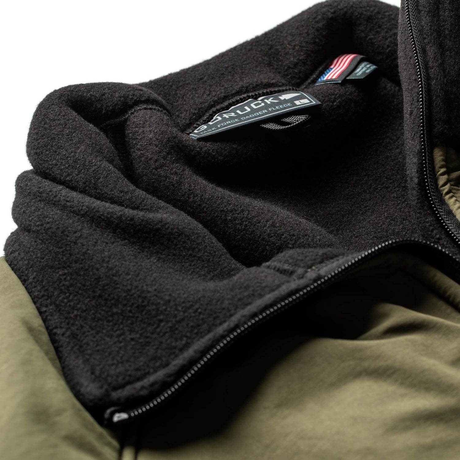 Close-up of GORUCK black fleece collar and olive green nylon shell jacket with zipper