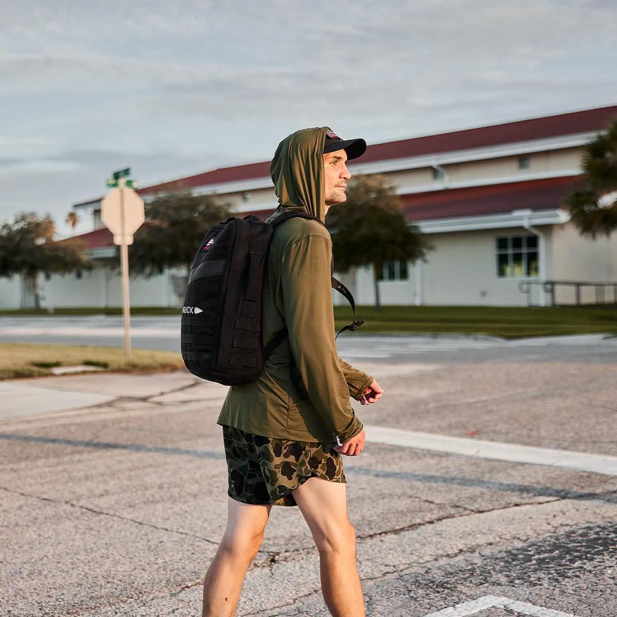 Man rucking in GORUCK Tough Mesh Hoodie and backpack outdoors on city street