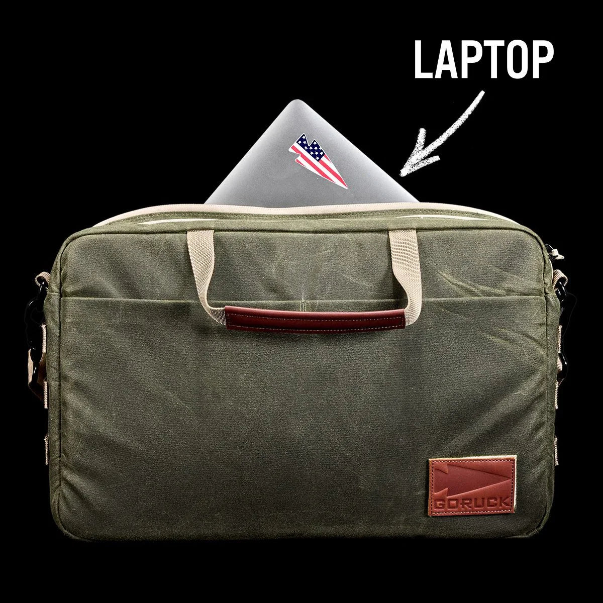 GORUCK olive green laptop bag with tan handles and leather patch, partially open showing laptop with American flag sticker