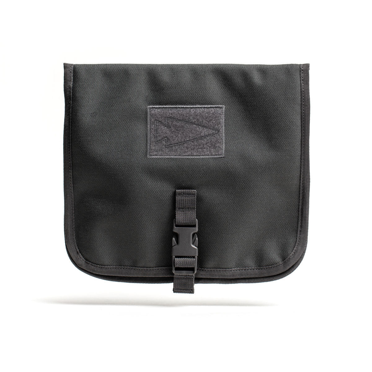 The Wire Dopp is a black fabric travel organizer pouch featuring a flap, buckle closure, and front rectangular patch—ideal for keeping your EDC essentials secure.