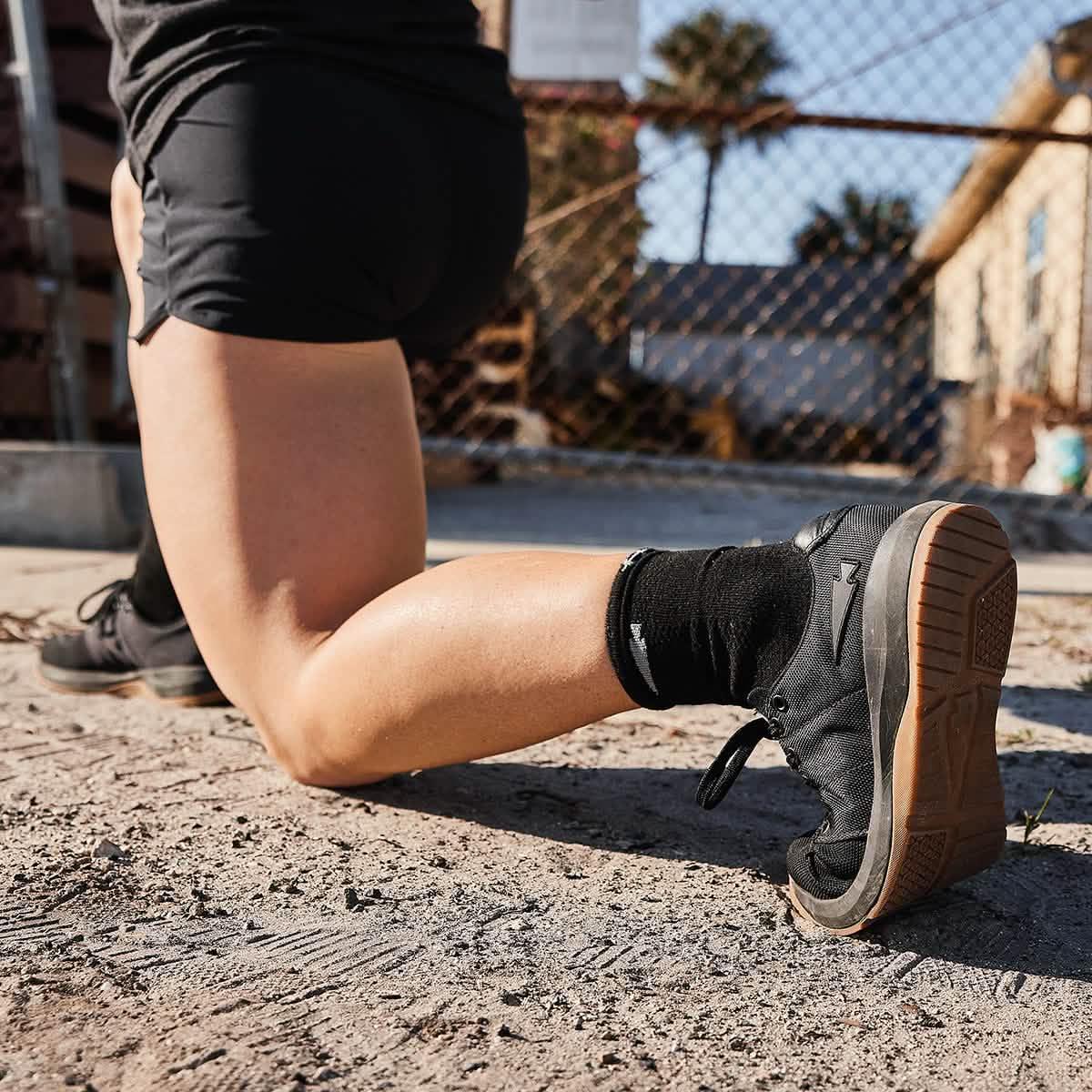 GORUCK black rucking shoe with gum sole worn outdoors on dirt, athletic training scene