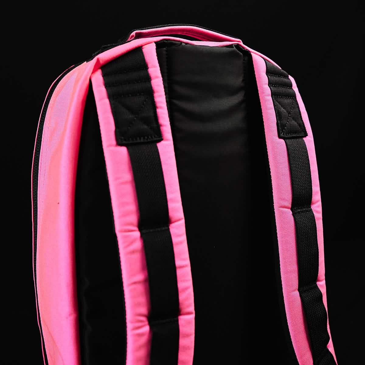 GORUCK pink rucksack padded shoulder straps close-up against black background