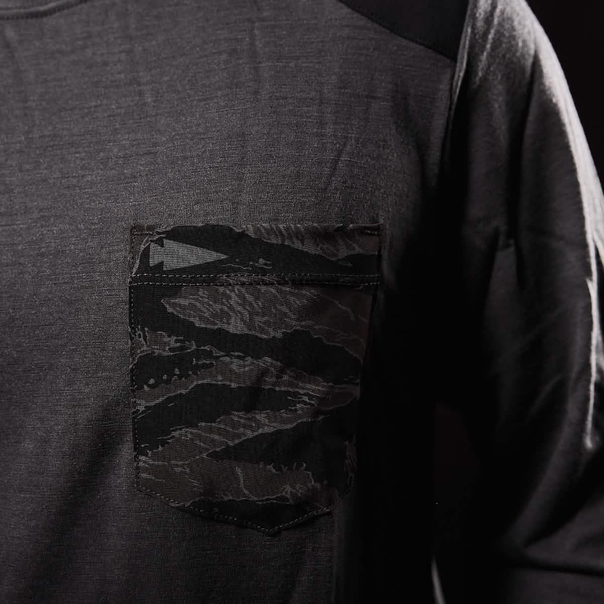 Close-up of charcoal long-sleeve shirt with black camo-patterned pocket detail on chest