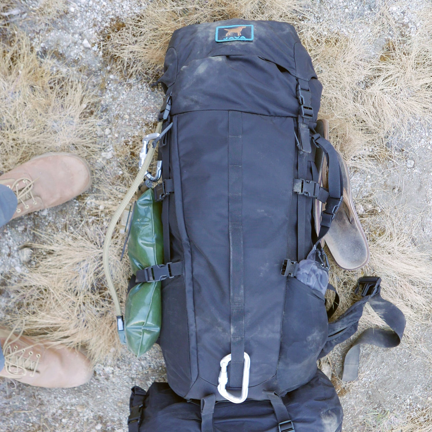 A GR MONSTER Bundle - PREORDER sits on the ground, accompanied by a green water bottle and brown boots nearby.