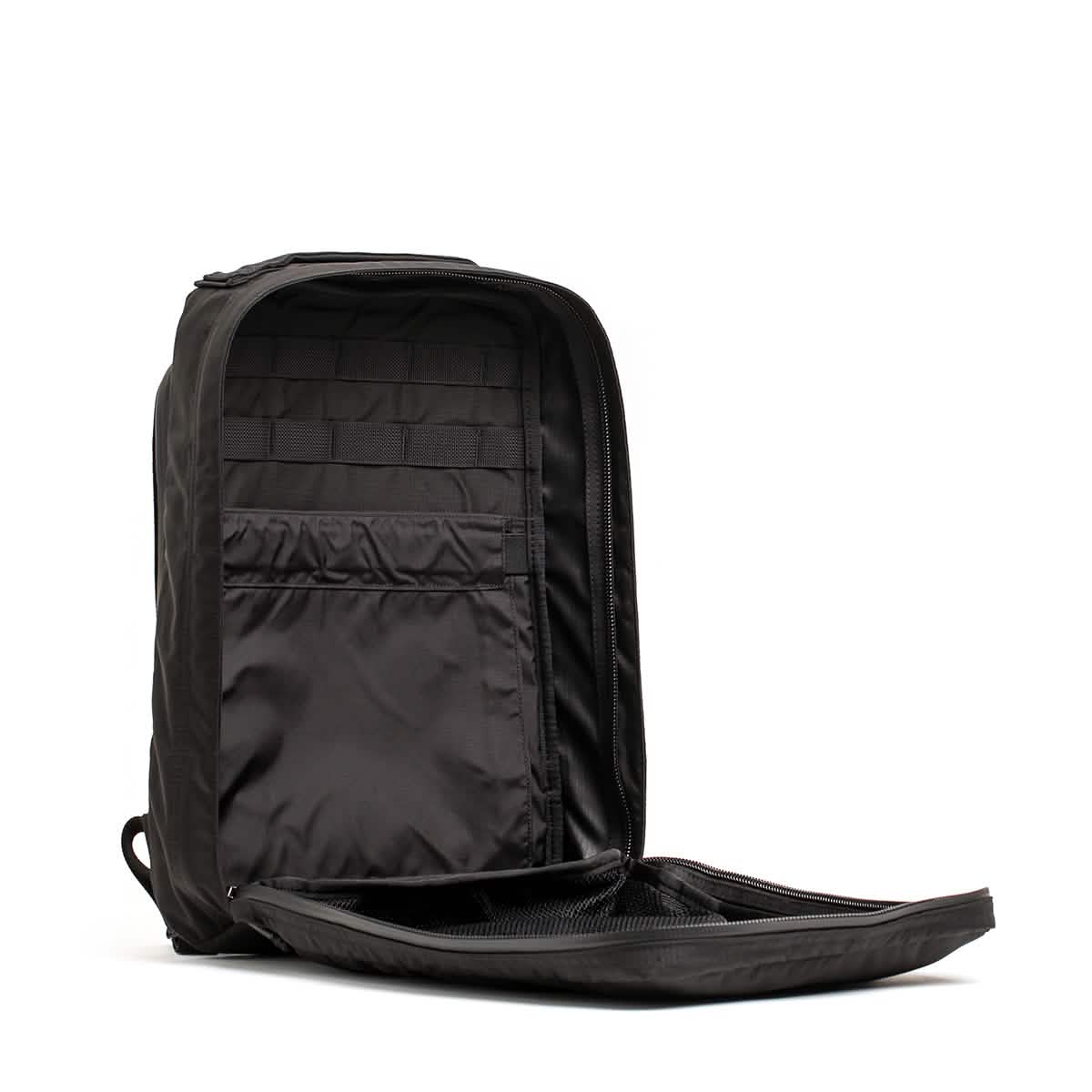 The GR0 - Ripstop ROBIC® backpack, shown upright with its water-resistant black exterior and unzipped front compartment, reveals interior pockets and mesh lining—ideal for minimalist everyday carry.