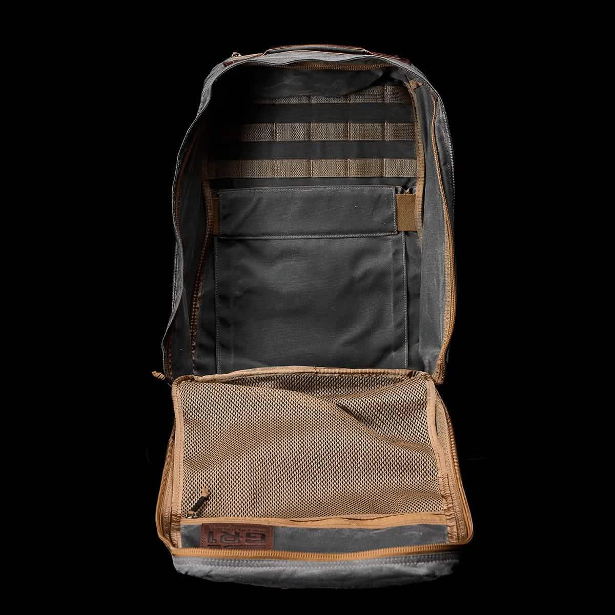 Open GORUCK Heritage Slate backpack showing organized interior with black fabric and tan mesh pocket