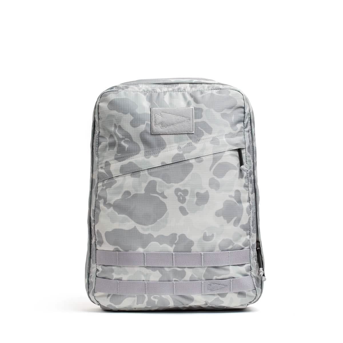 The GR0 - Ripstop ROBIC® is a light gray camo water-resistant backpack featuring a front zipper pocket, MOLLE webbing, and a blank patch—ideal for minimalist everyday carry.