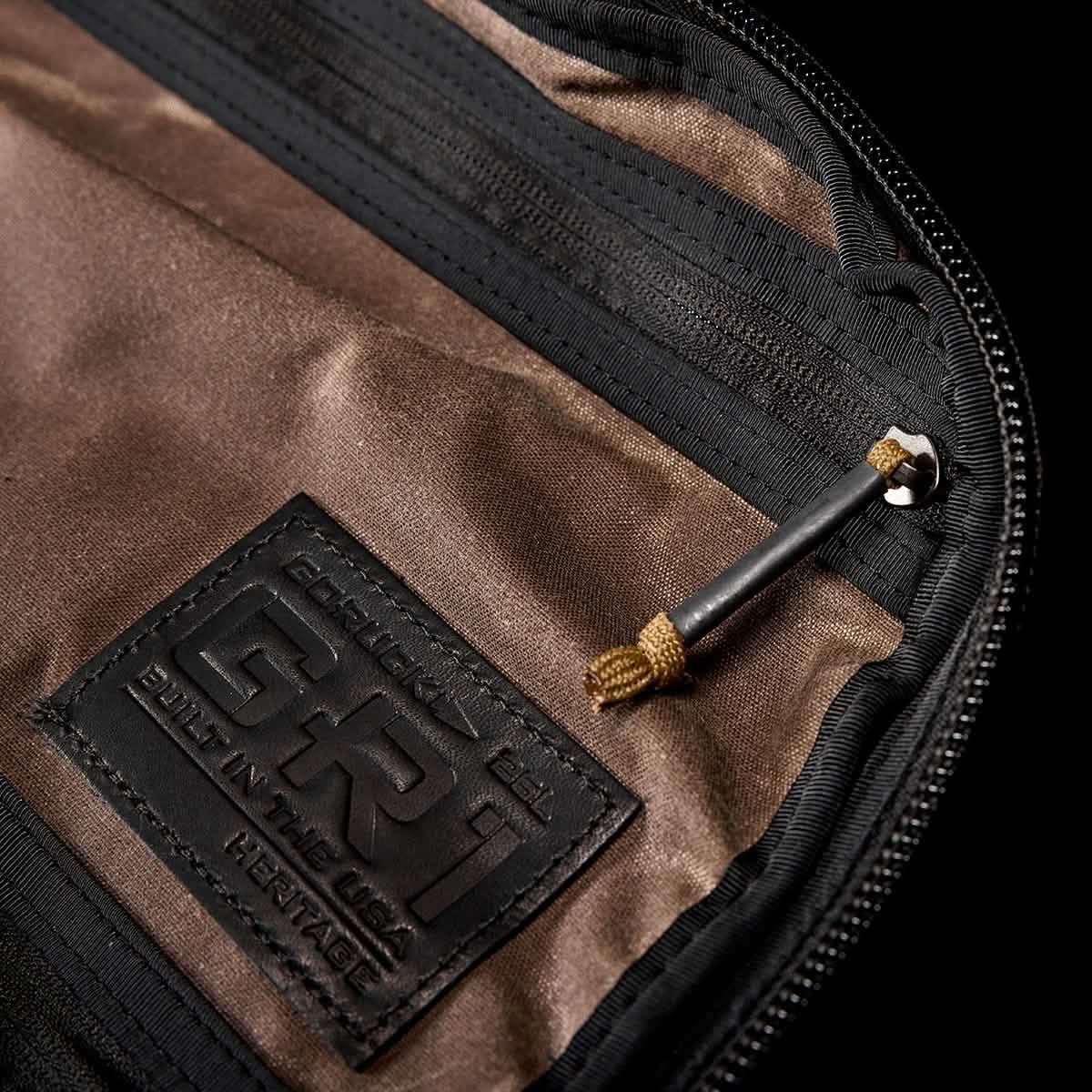 Close-up of GORUCK Heritage dark oak backpack interior with black zipper and logo patch