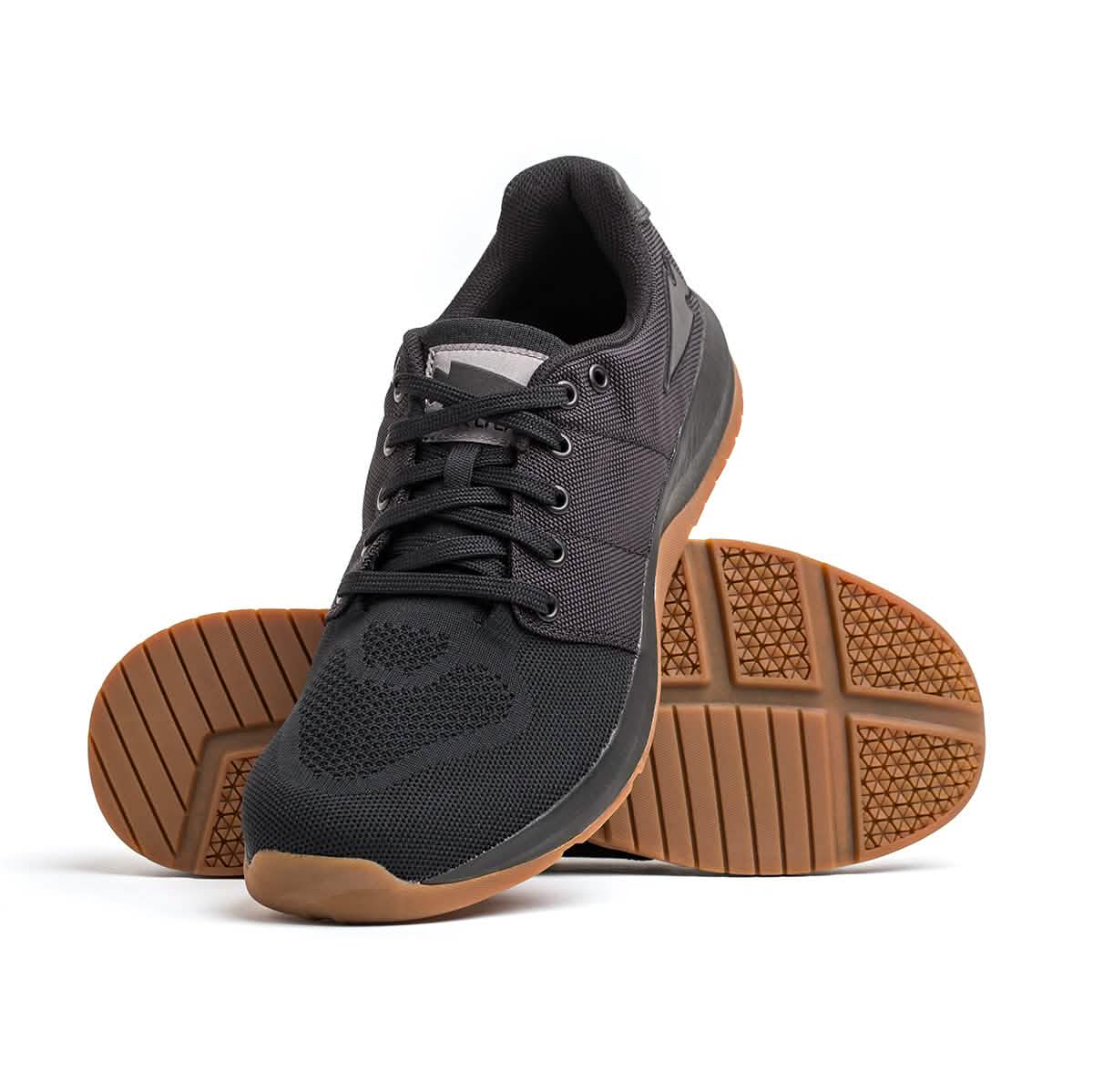The Men's Ballistic Trainers - HULK from GORUCK feature brown rubber soles and a mesh upper design. One shoe is displayed upright, while the other is shown on its side to highlight the textured sole pattern, making them perfect for workouts.