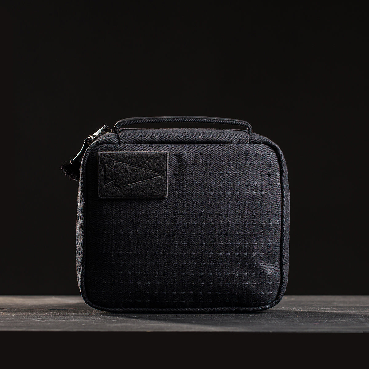A compact, black GR2 Field Pocket - GRXC2 Samurai 2.0, crafted from JPXDP fabric, rests on a dark surface with a black background.