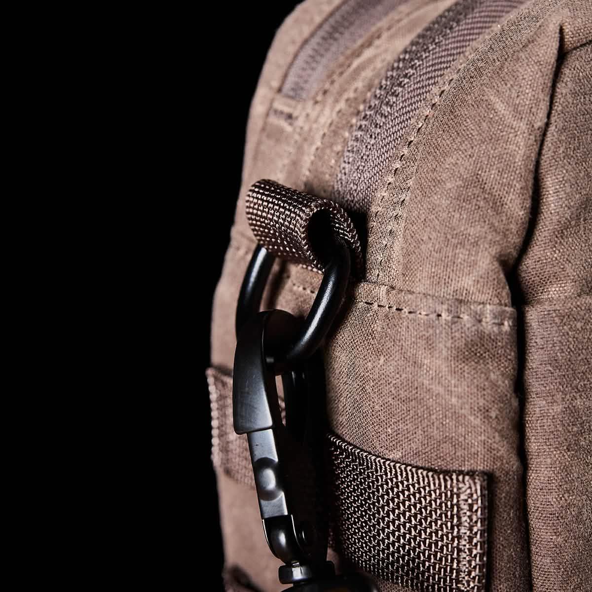 Close-up of brown rugged GORUCK gear fabric with black sturdy carabiner attached