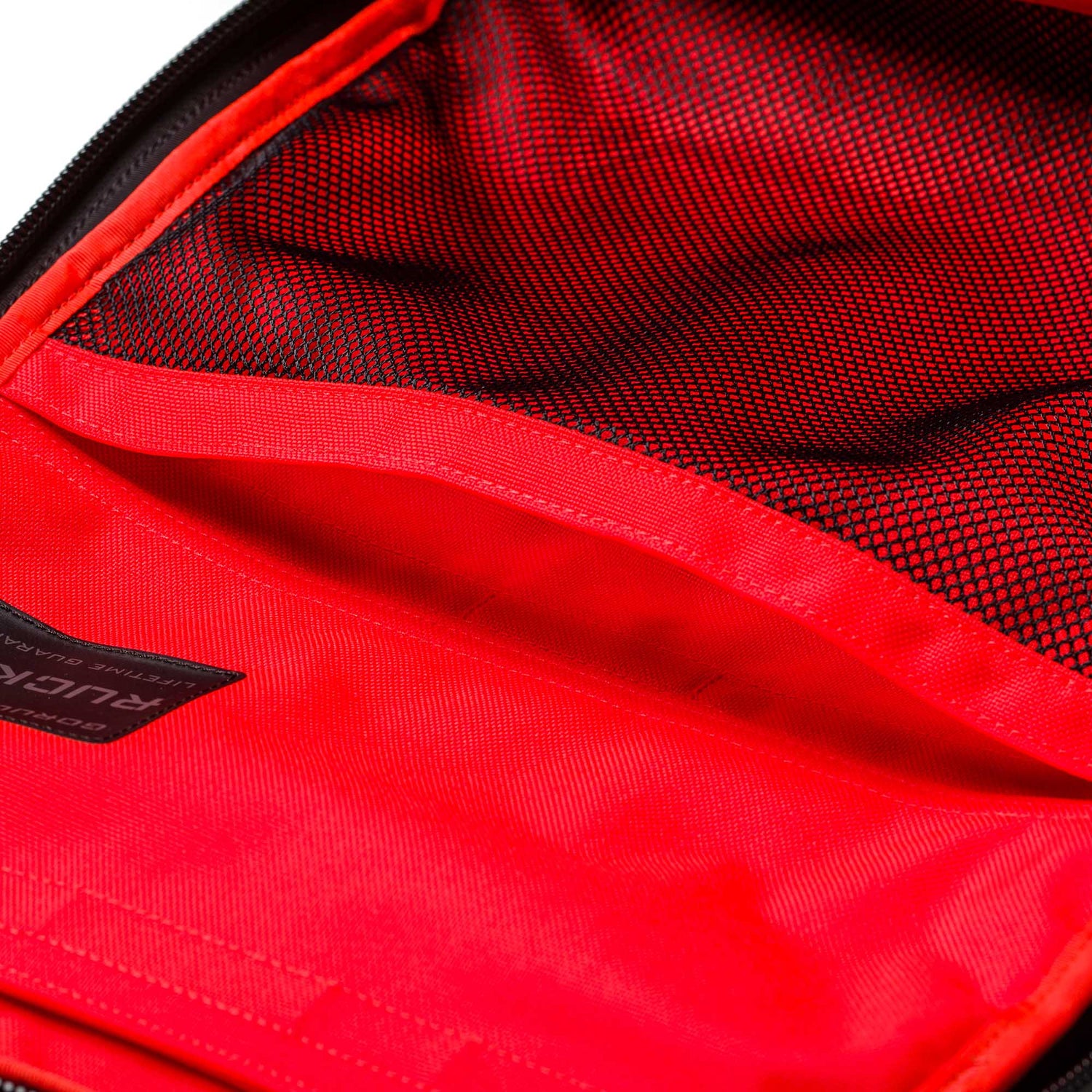 Close-up of the Rucker 5.0’s red interior featuring a black mesh pocket and a visible label on the lining, perfect for your next rucking adventure.