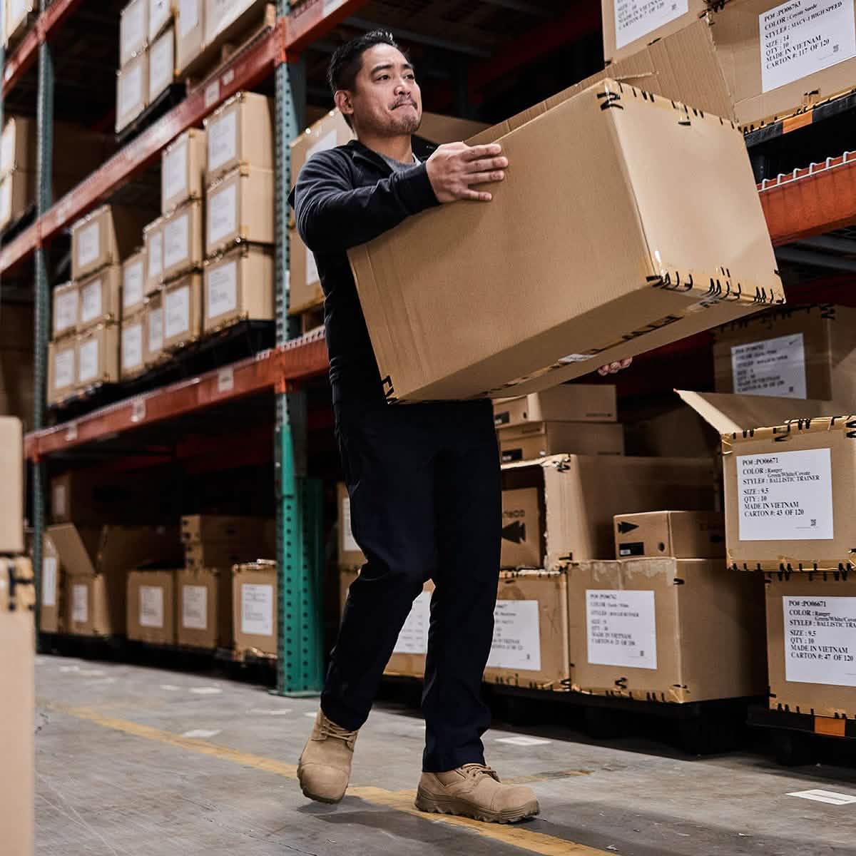 Man lifting large box in warehouse, GORUCK rucking gear inventory storage shelves