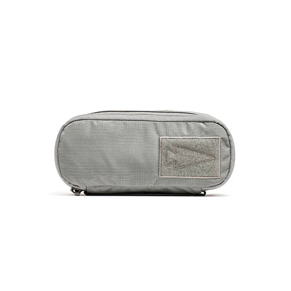 The Shadow Pockets are gray zippered pouches crafted from tough 500D Cordura, featuring a rectangular front patch with an arrow design—perfect for organizing your ruck.