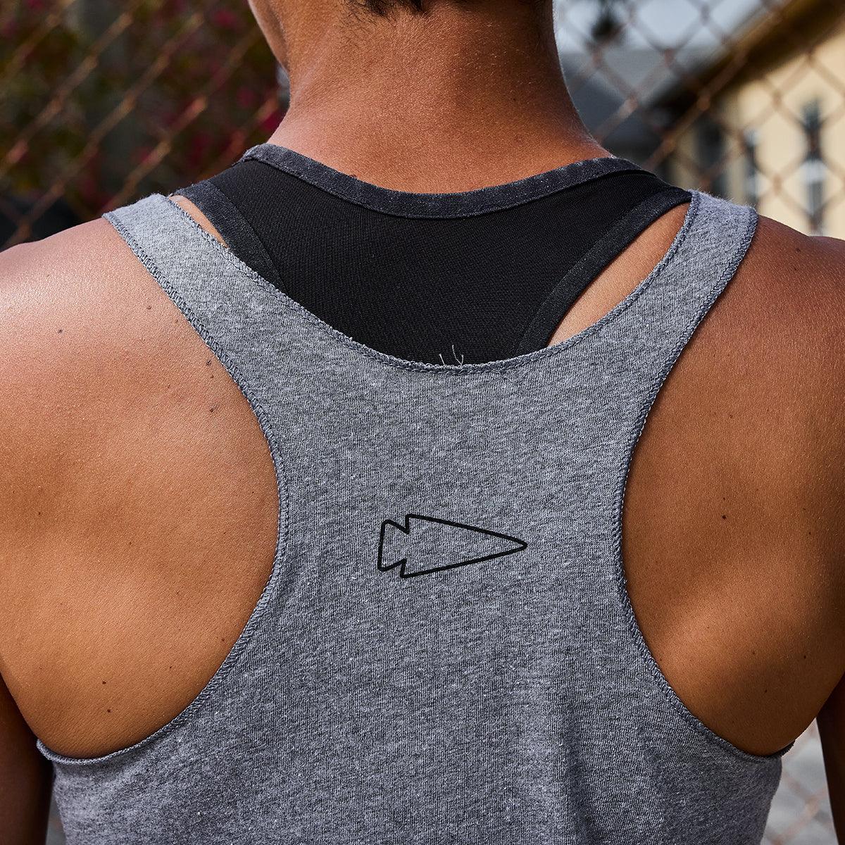 Close-up of a person wearing a gray GORUCK tank top with a black arrowhead logo on the back
