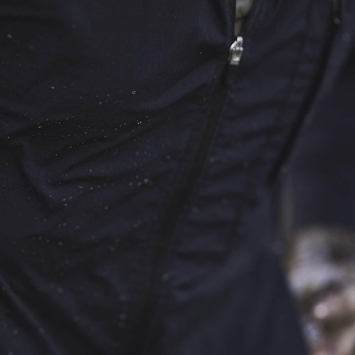 Close-up of black GORUCK windbreaker with water droplets highlighting water resistance