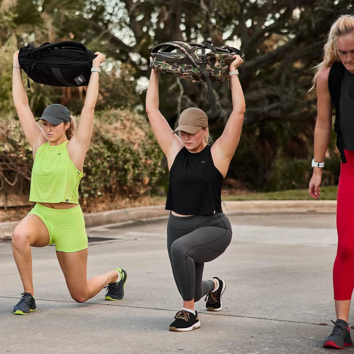 Women rucking outdoors with GORUCK backpacks during a fitness workout