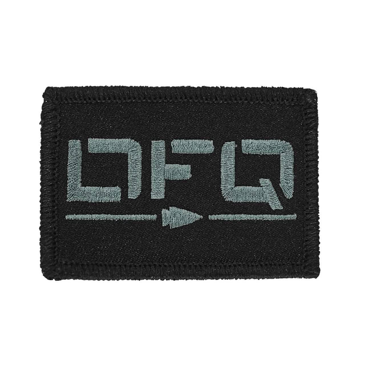 Black rectangular patch with light gray embroidered letters