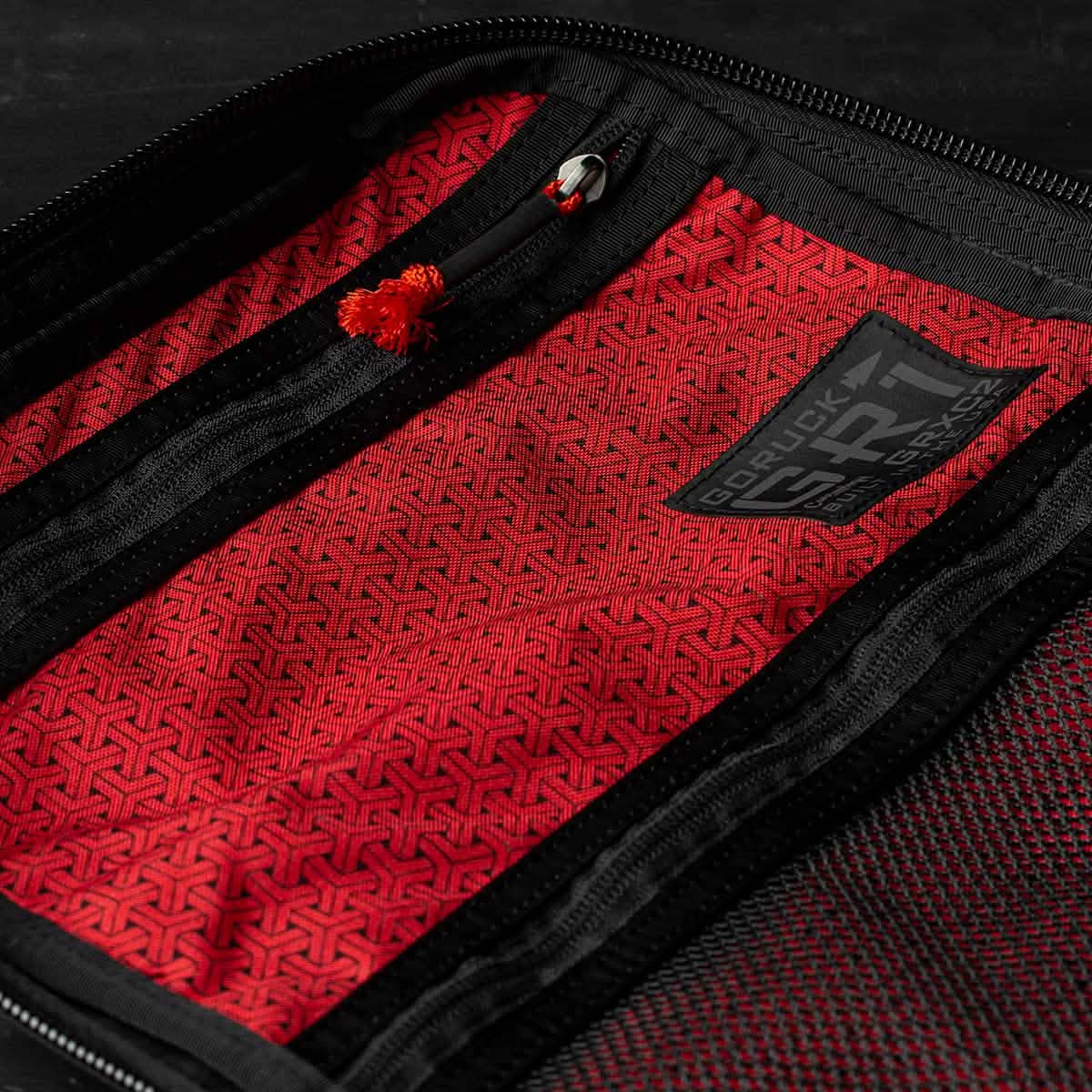 The GR1 USA x Carryology - GRXC2 Samurai features a red Japanese cotton fabric pouch with black zippers, geometric patterns, and a small logo patch on the inner lining.