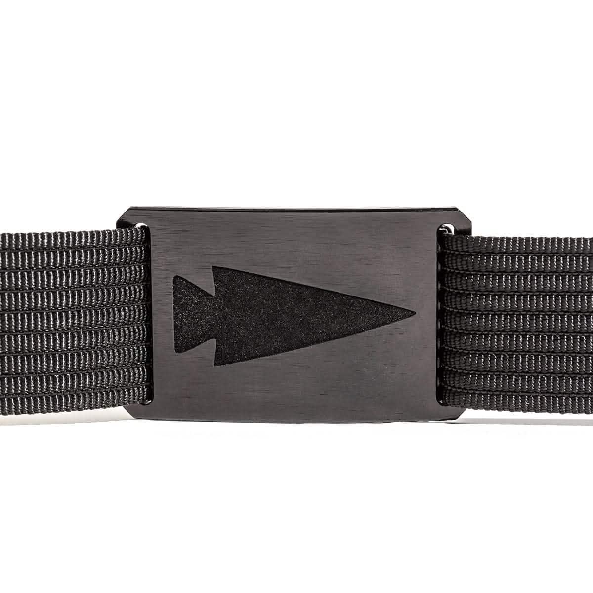 A close-up of the Spearhead Web Belt by Grip 6, featuring a rectangular metal buckle with an arrowhead cutout. The black belt is crafted from textured fabric and boasts a low-profile design against a plain white background.