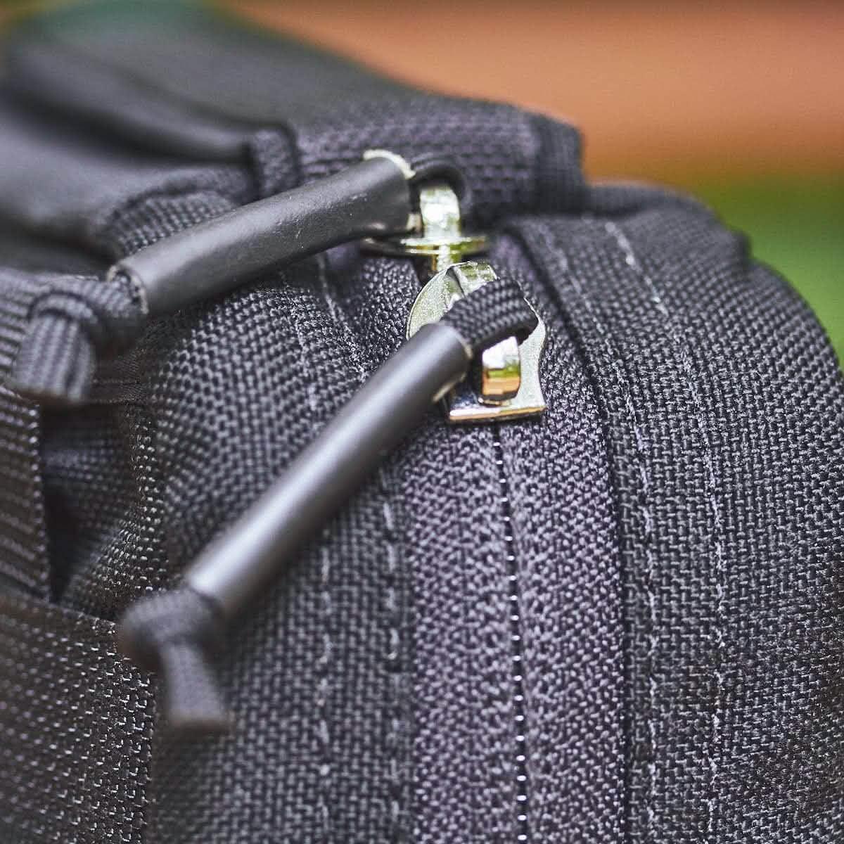 Close-up of a durable black zipper pull on rugged GORUCK tactical gear fabric