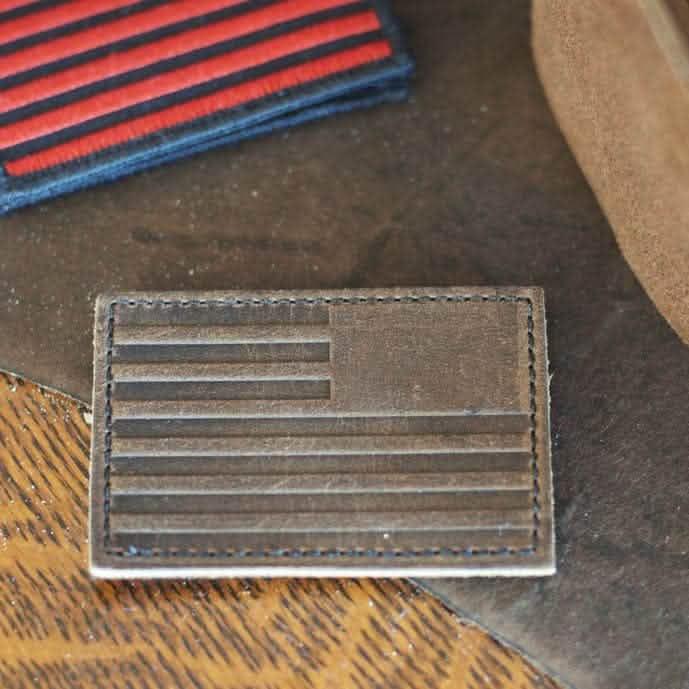 GORUCK leather reverse flag patch on brown surface, rugged rucking gear accessory