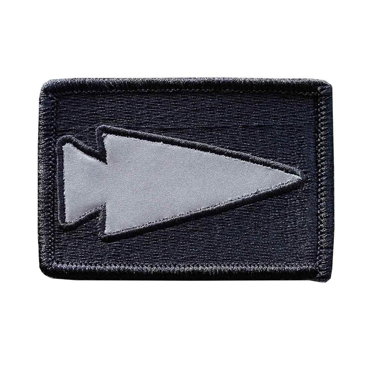 GORUCK reflective spearhead patch on black rectangular fabric background