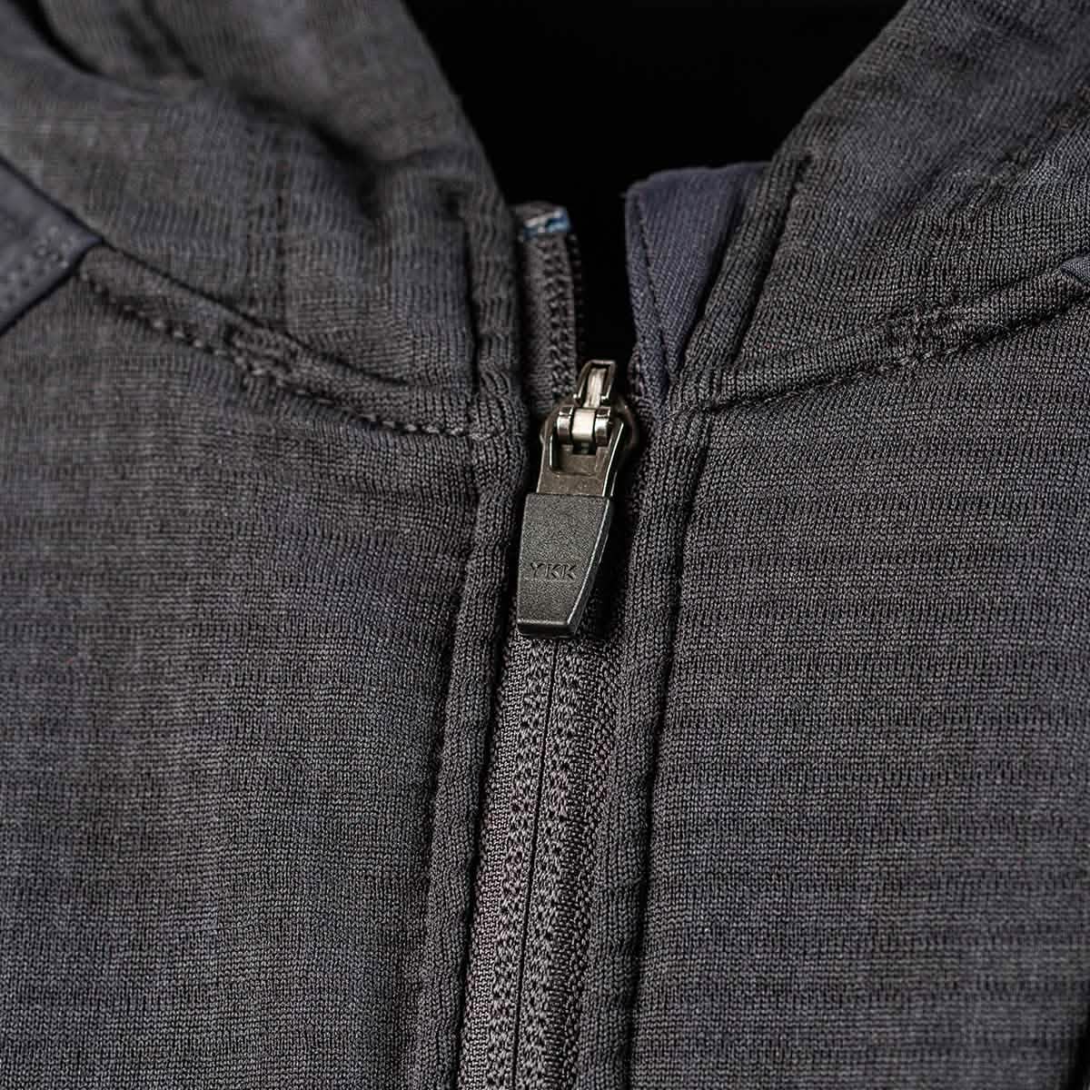 Close-up of a dark gray Men’s Full Zip - Polartec Grid Fleece jacket by GORUCK with a partially zipped zipper. The metal zipper pull features the YKK engraving, highlighting its quality. The textured surface suggests durable craftsmanship and style.