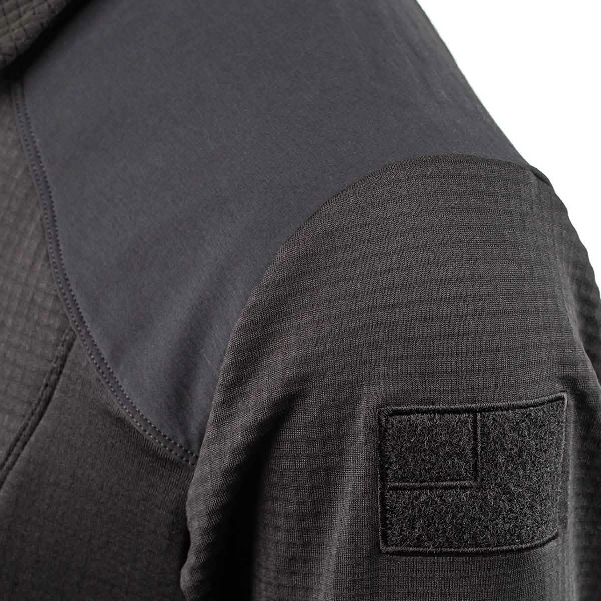 Close-up of a black Men’s Half Zip by GORUCK, made from Polartec Grid Fleece, boasting a textured design with a velcro patch on the shoulder. The fabric displays unique patterns on the shoulder and sleeve, providing both style and durability.