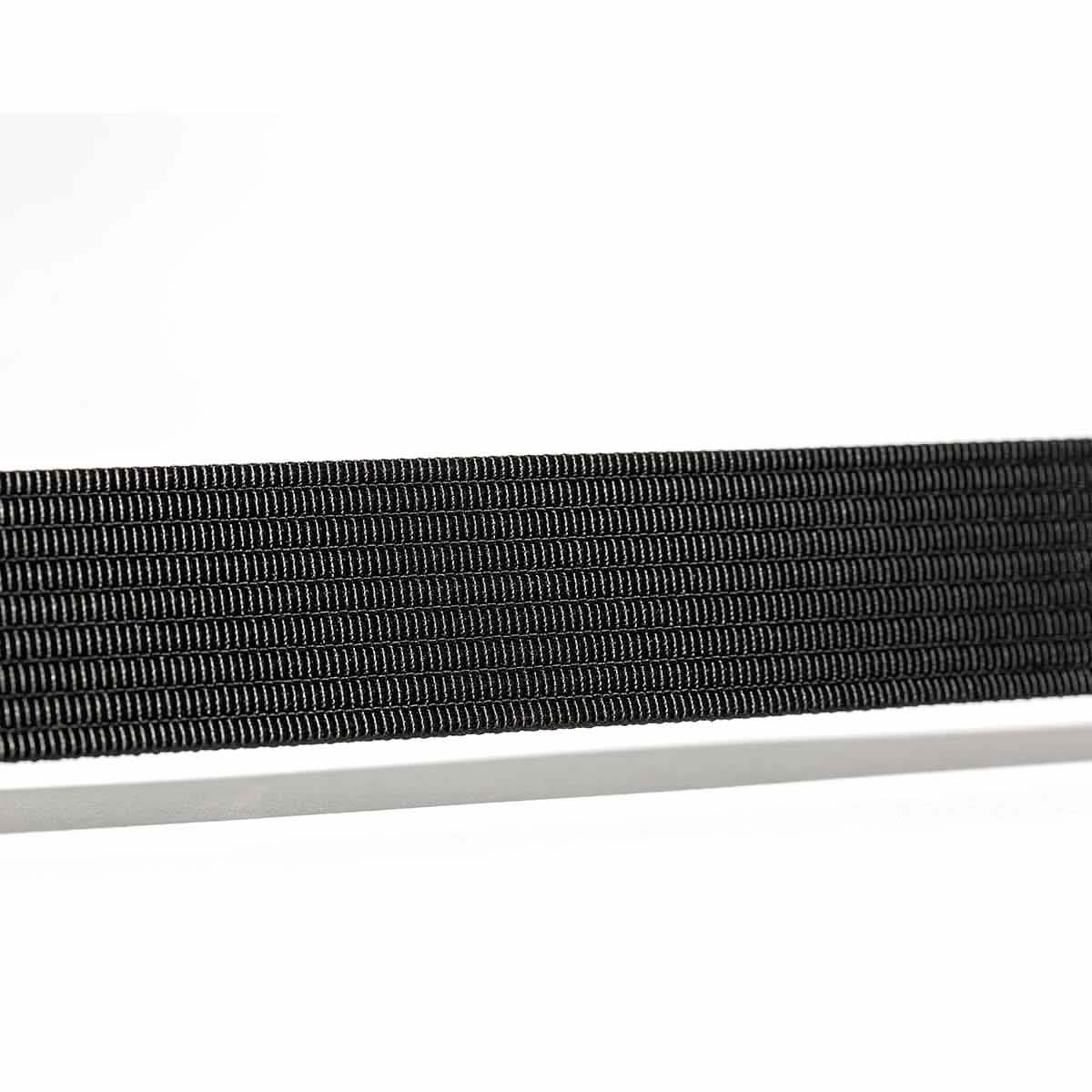 Close-up of a black rectangular object, possibly a Spearhead Web Belt by Grip 6, laid horizontally against a white background. The low profile design features thin, parallel ridges and a no-slip locking mechanism for added security.