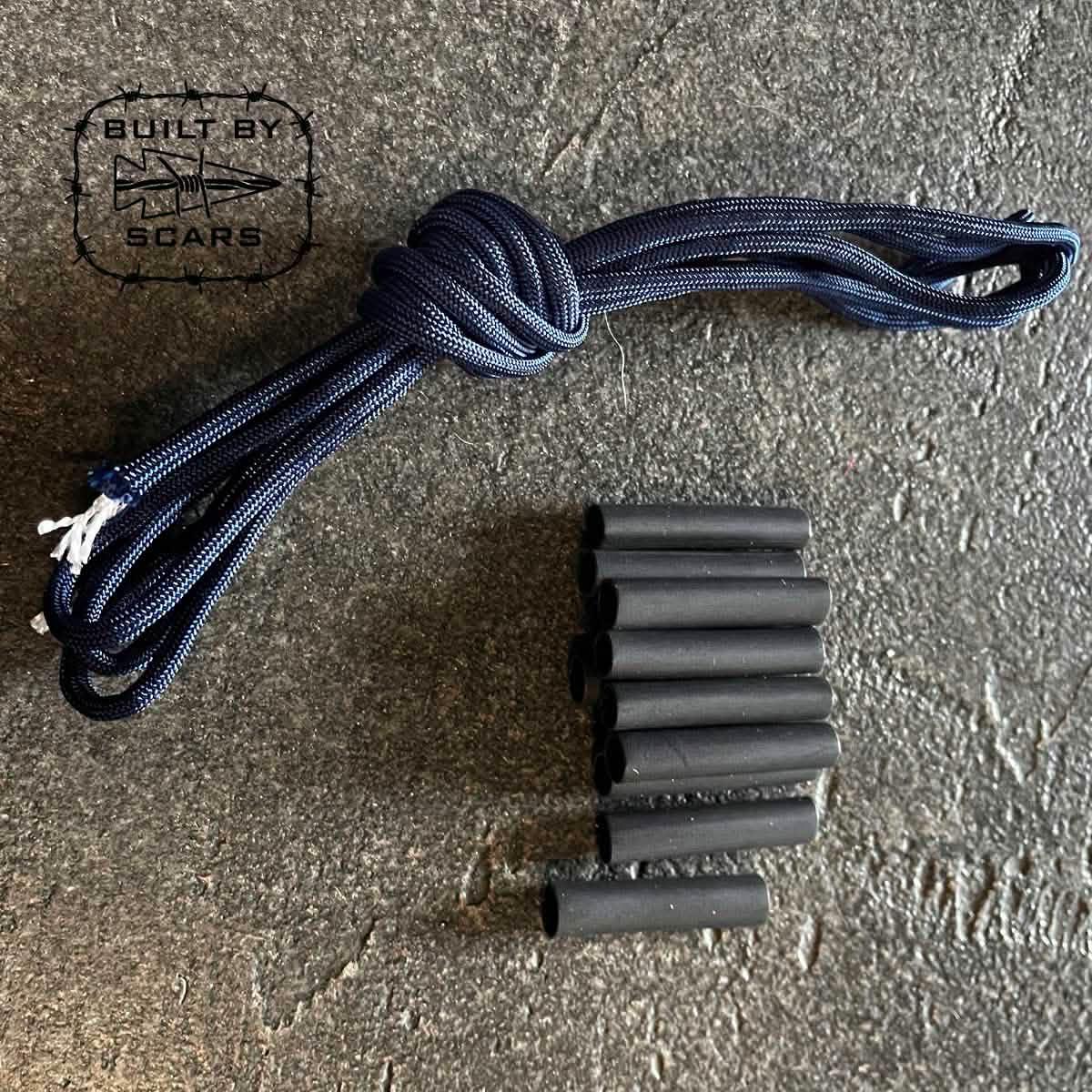 Navy blue paracord bundle with black heat shrink tubes on textured surface, GORUCK gear by SCARS