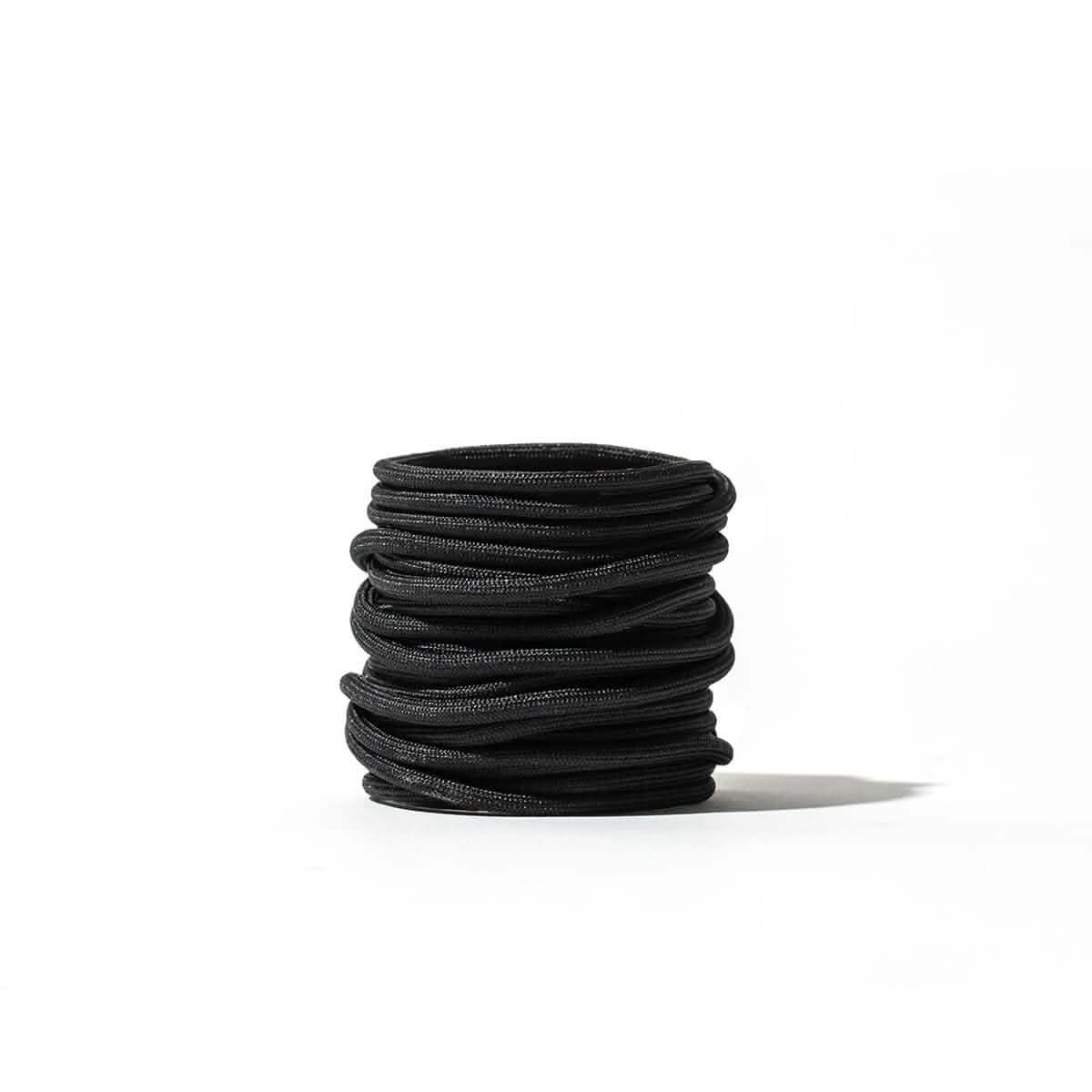 A stack of GORUCK's Speed Laces, crafted in sleek black, is meticulously arranged against a plain white background.