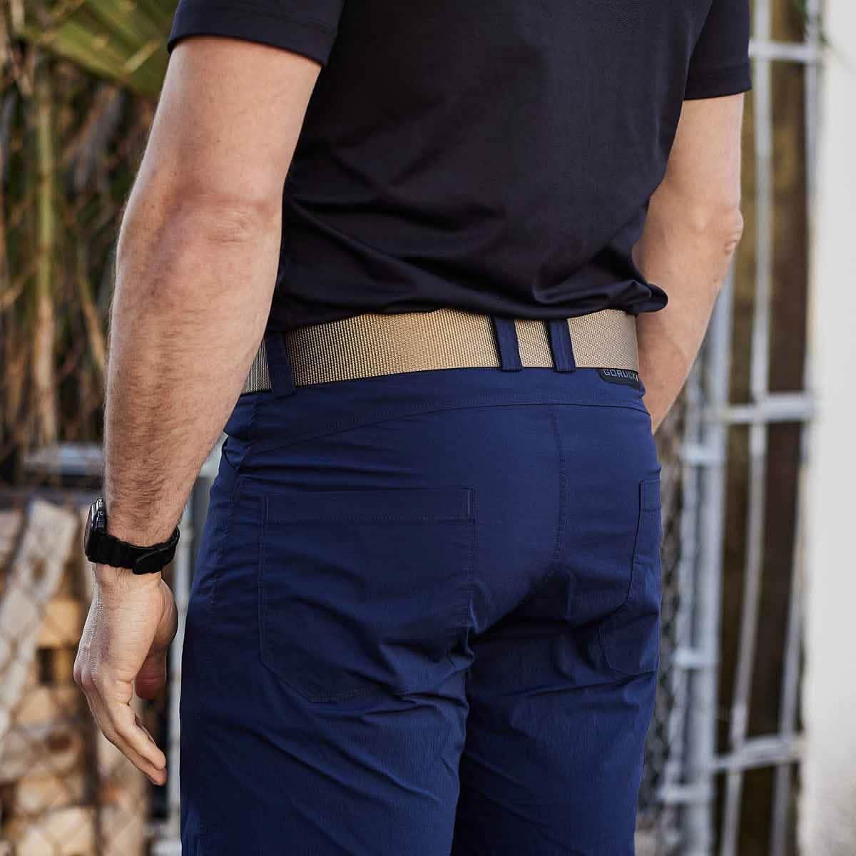 Back view of a man wearing GORUCK tactical coyote belt with navy rucking pants and a black watch