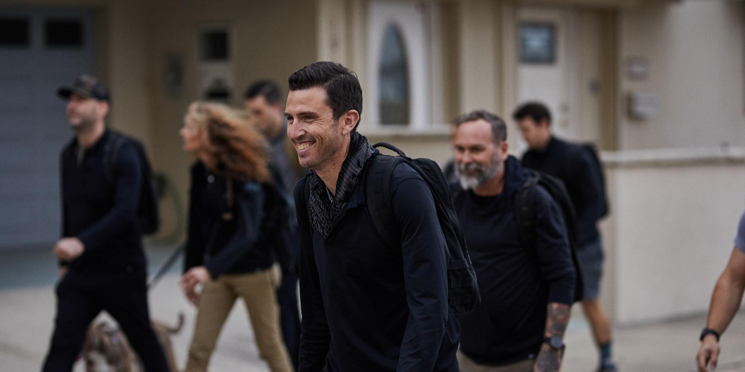 Group of people rucking outdoors with GORUCK gear, smiling and active in urban setting