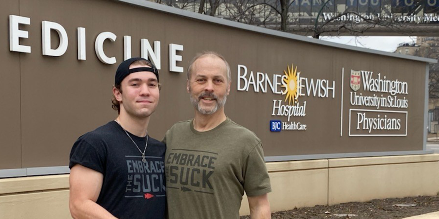 Two men in GORUCK Embrace the Suck shirts standing outside Barnes Jewish Hospital sign