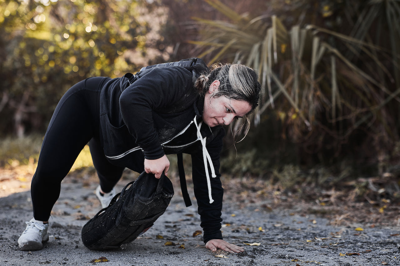 Woman performing outdoor rucking exercise with GORUCK weighted sandbag