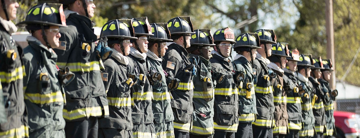 Line of firefighters in full protective gear and helmets, outdoors, GORUCK tough rucking gear theme