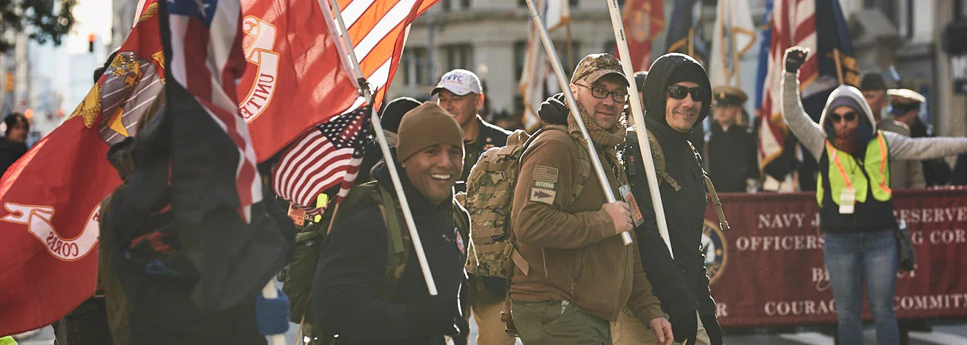 Group of veterans marching with flags in a city street during a veteran support event